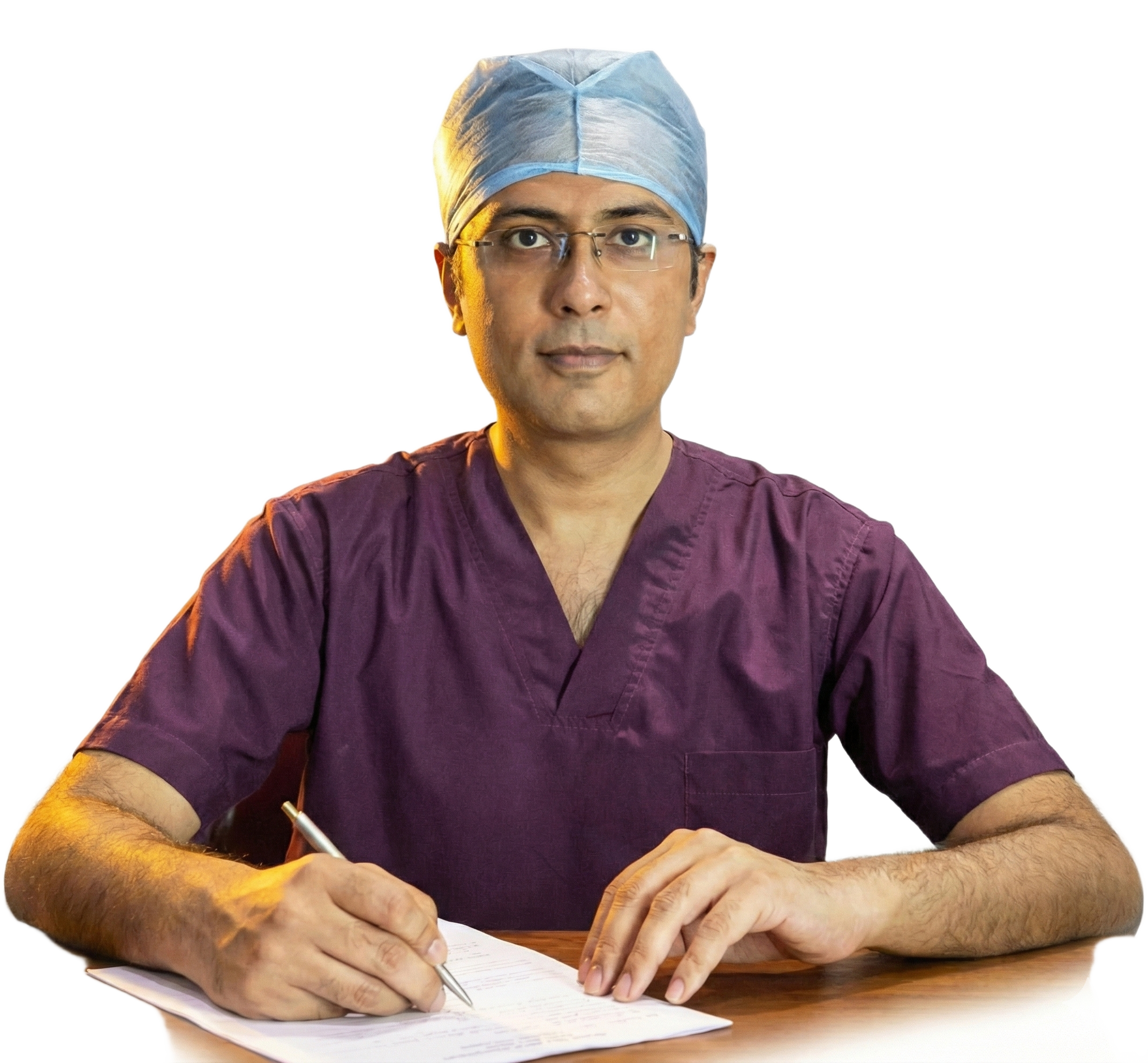 DR Vishal Purohit in surgeons cap and writing on a presciptin pad looking at the viewer